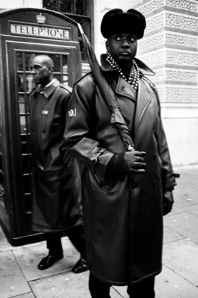Two members of the Nation of Islam (NOI) stand next to a British red telephone box during the “Million Man March” between Parliament Square and Trafalgar Square in central London. Image copyright © Thaddeus Pope, 2006.