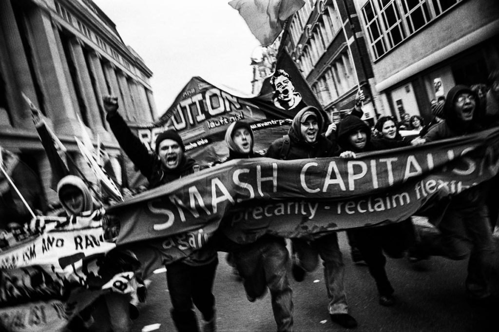“Smash Capitalism”, London, England, October 2004. Following a day of seminars, workshops and cultural events at The Third European Social Forum – an event which focused on addressing major European and global issues, with particular attention paid to coordinating efforts against the ongoing occupation of Iraq – tens of thousands of antiwar and anti-capitalist protestors held an impassioned demonstration in central London. Image copyright © Thaddeus Pope 2004.