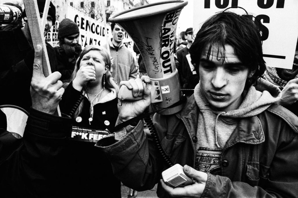 Students gather in Parliament Square to protest against the introduction of top-up fees in the UK, London, 2004. In January 2004 – an hour or so after this photograph was taken – Tony Blair’s Labour government won its vote to introduce student top-up fees, thereby allowing British universities, by law, to set their own level of tuition fees, rather than adhering to the rate previously set by the government. Though the introduction of student top-up fees faced widespread opposition, with many arguing it would create a two-tiered education system in the UK, the government was able to narrowly win the decision with 316 voting for the bill and 311 against. The rate set by the government at that time was £1,050 a year for undergraduates. Ten years later, the average annual cost of tuition fees in the UK is now £9,188, which makes university tuition fees in England among the highest in the world.