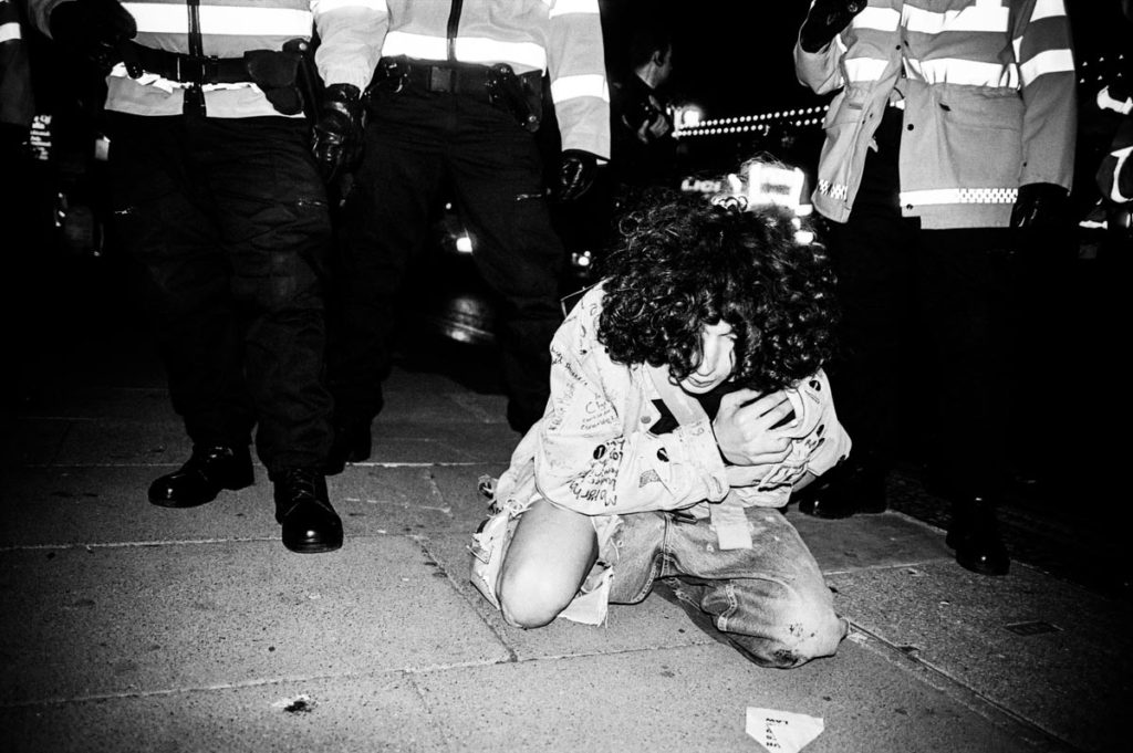 A man is injured after police clash with anti-war protestors on Brighton Seafront, England (2003). Image © Thaddeus Pope