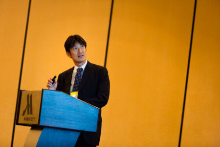 Takeshi Komoto, Executive Director of the Japan External Trade Organization’s (JETRO) New York Office, gives a Keynote Presentation titled “Abenomics and the Three Arrows” at The North American Conference on the Social Sciences (NACSS) in Rhode Island, USA Takeshi Komoto, Executive Director of the Japan External Trade Organization’s (JETRO) New York Office, gives a Keynote Presentation titled “Abenomics and the Three Arrows” at The North American Conference on the Social Sciences (NACSS) in Rhode Island, USA