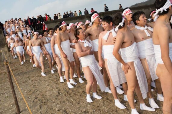 With family and friends looking onwards, the men reach the beach and prepare to receive blessings before entering the sea.