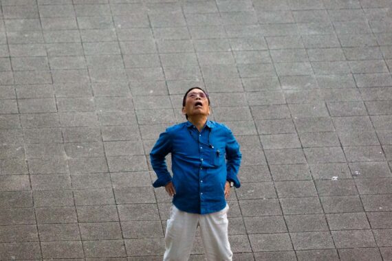 Taxi driver stretches while taking a break, Kobe, Hyogo Prefecture, Japan.