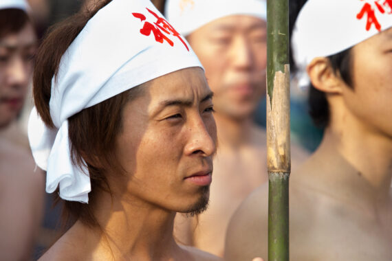 The shin-otoko listens intently to the shinto priests leading the ritual purification process.