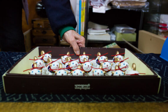 In the small onsen town of Iwami-cho Iwai on the west cost of Japan, Mrs Ogura runs a shop called "Ogura-ya" which specialises in carving wooden figurines of the twelve animals in the Japanese zodiac. Wood carving has been in the Ogura family for approximately 1000 years. And, although her storefront is very small, Mrs Ogura has fulfilled lucrative orders with major Japanese stores, including MUJI, and images of her wood carvings have appeared on special edition stamps available nationwide.