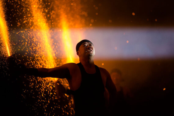 Light illuminates the face of a man holding an ignited tezutsu hand-held firework during Bon Odori in Nagoya, Japan.