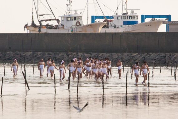 Having cleansed themselves in the sea, the men make their way back onto the beach.