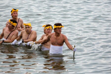 Local men drag an immense floating mikoshi across the shallow water of the Mikawa bay during the annual Miya Festival in Gamagori, Aichi Prefecture, Japan.