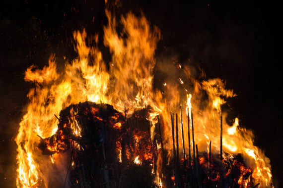 Smoke billows from the suzumi as the two towers of dry pampas grass and bamboo burn brightly against the night sky.