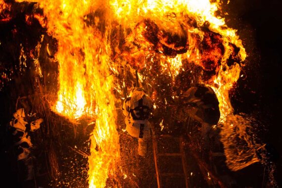 With bundles of burning grass falling on their heads and smoke billowing in their faces, the men violently shake the burning suzumi.