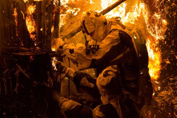 In an impressive display of courage and teamwork, the men tear at the towering inferno, forcing it apart and weakening its structure.