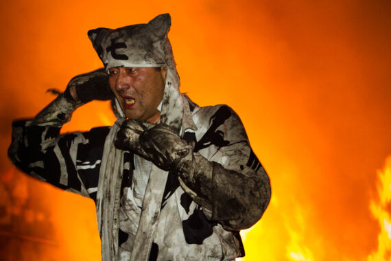 The men remove their masks to reveal faces fatigued by the immense physical effort of the task.