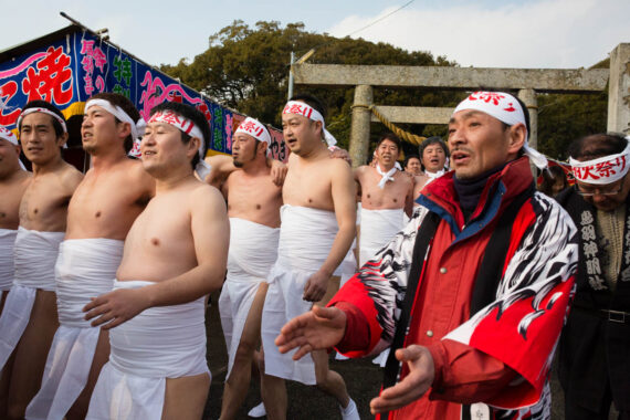 Older participants pass through the torii gate at Toba Shinmeisha Shrine on their way to the sea for misogi.