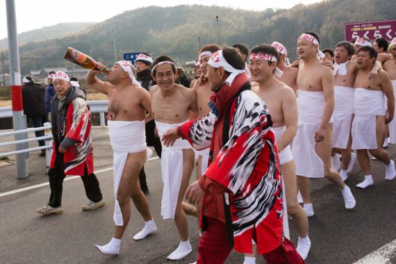 With arms linked together, the men sing songs and drink sake as they make their way to the sea for misogi.