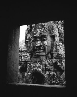 Prasat Bayon, Angkor Thom, Cambodia, 2009.
Built in the late 12th or early 13th century as the official state temple of the Mahayana Buddhist King Jayavarman VII, the Bayon stands at the centre of Jayavarman's capital, Angkor Thom. Following Jayavarman's death, it was modified and augmented by later Hindu and Theravada Buddhist kings in accordance with their own religious preferences. The smiling stone faces at Prasat Bayon in the Angkor Archaeological Park