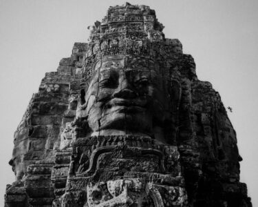 Prasat Bayon, Angkor Thom, Cambodia, 2009.
Built in the late 12th or early 13th century as the official state temple of the Mahayana Buddhist King Jayavarman VII, the Bayon stands at the centre of Jayavarman's capital, Angkor Thom. Following Jayavarman's death, it was modified and augmented by later Hindu and Theravada Buddhist kings in accordance with their own religious preferences. The smiling stone faces at Prasat Bayon in the Angkor Archaeological Park